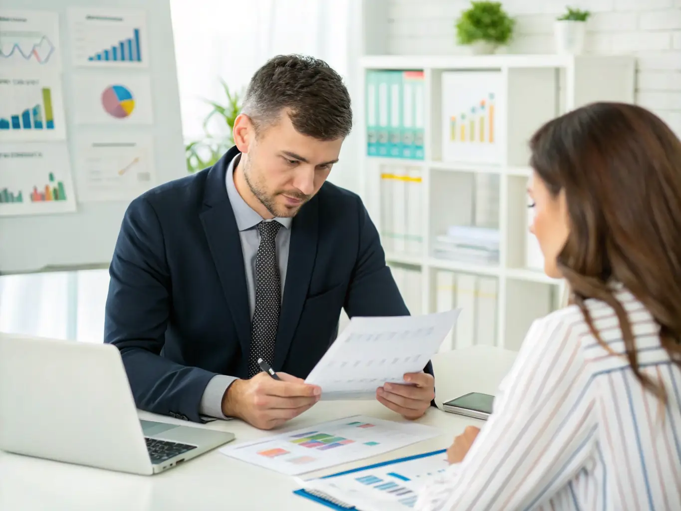 An accountant reviewing financial statements with a client in a modern office setting, symbolizing rcmanagementservicesllc's basic accounting services.